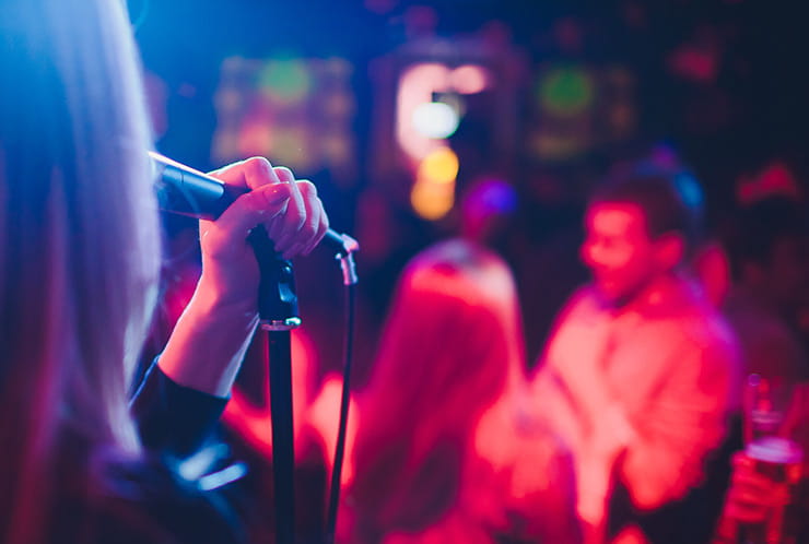 A singer singing into a microphone at Hollywood casino.