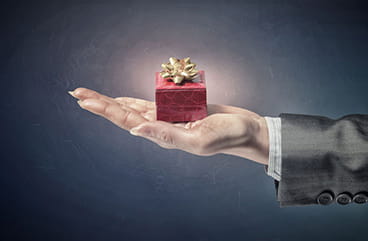A hand holding a promotion gift box.