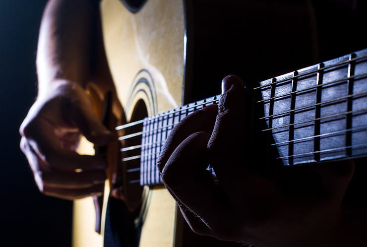 A man playing an acoustic guitar.