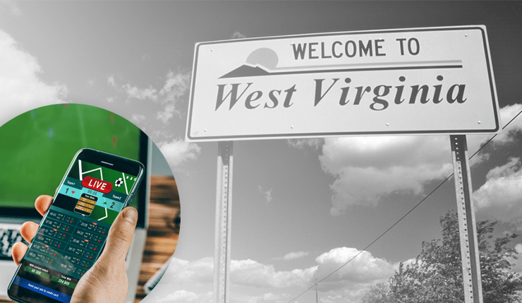 A person placing a sports bet on a smartphone in front of a sign that says Welcome to West Virginia. 